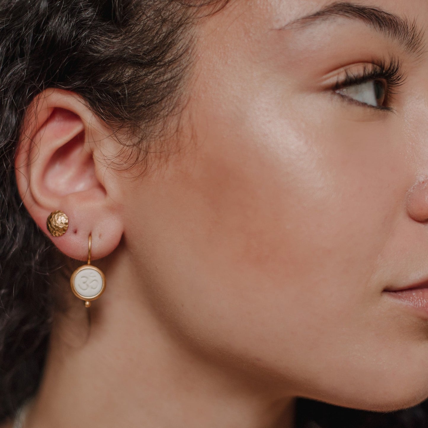 Die Ohrhänger OHM bestehen aus Sterlingsilber, einer galvanischen Vergoldung sowie Porzellan