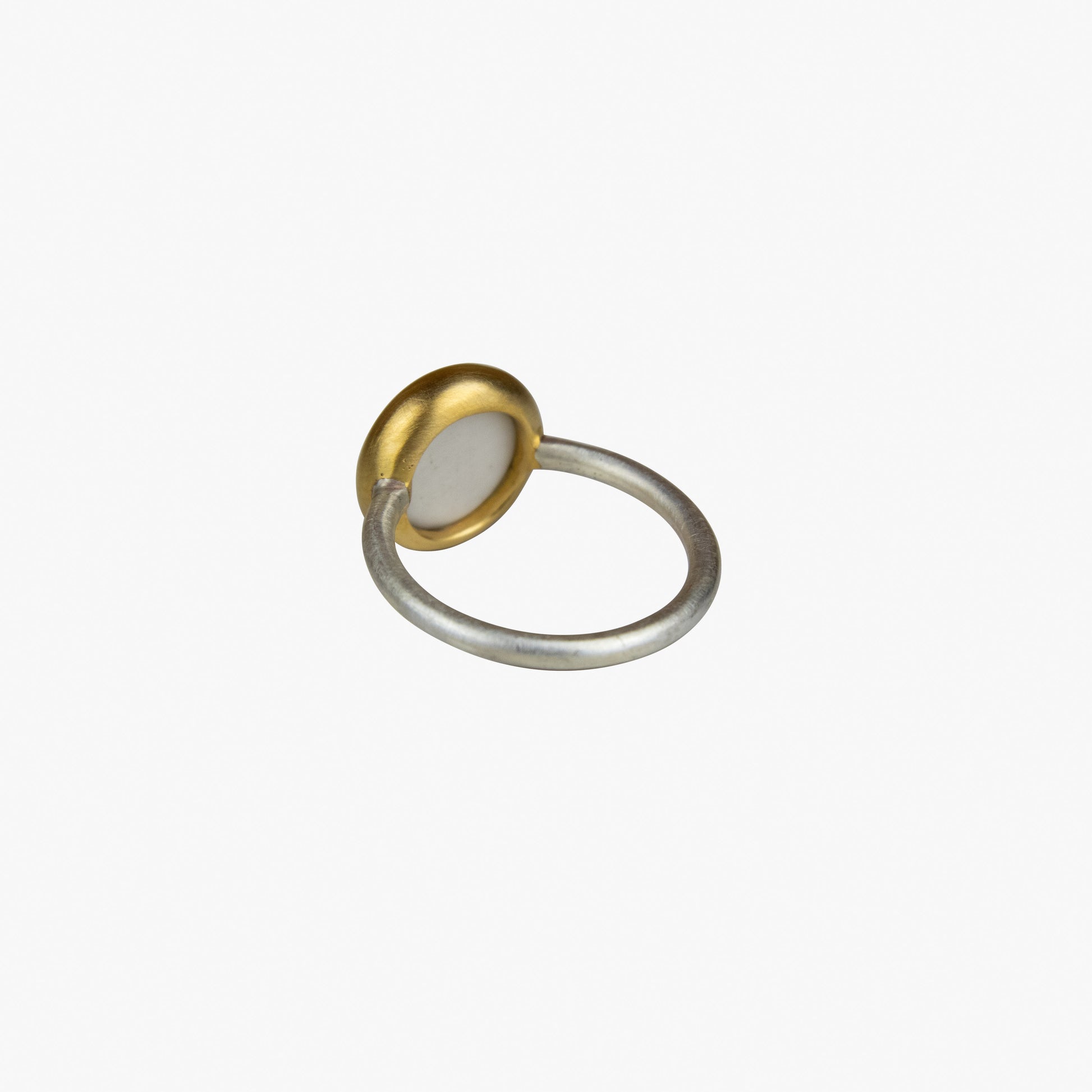 Der Ring OHM besteht aus Sterlingsilber, einer galvanischen Vergoldung sowie Porzellan