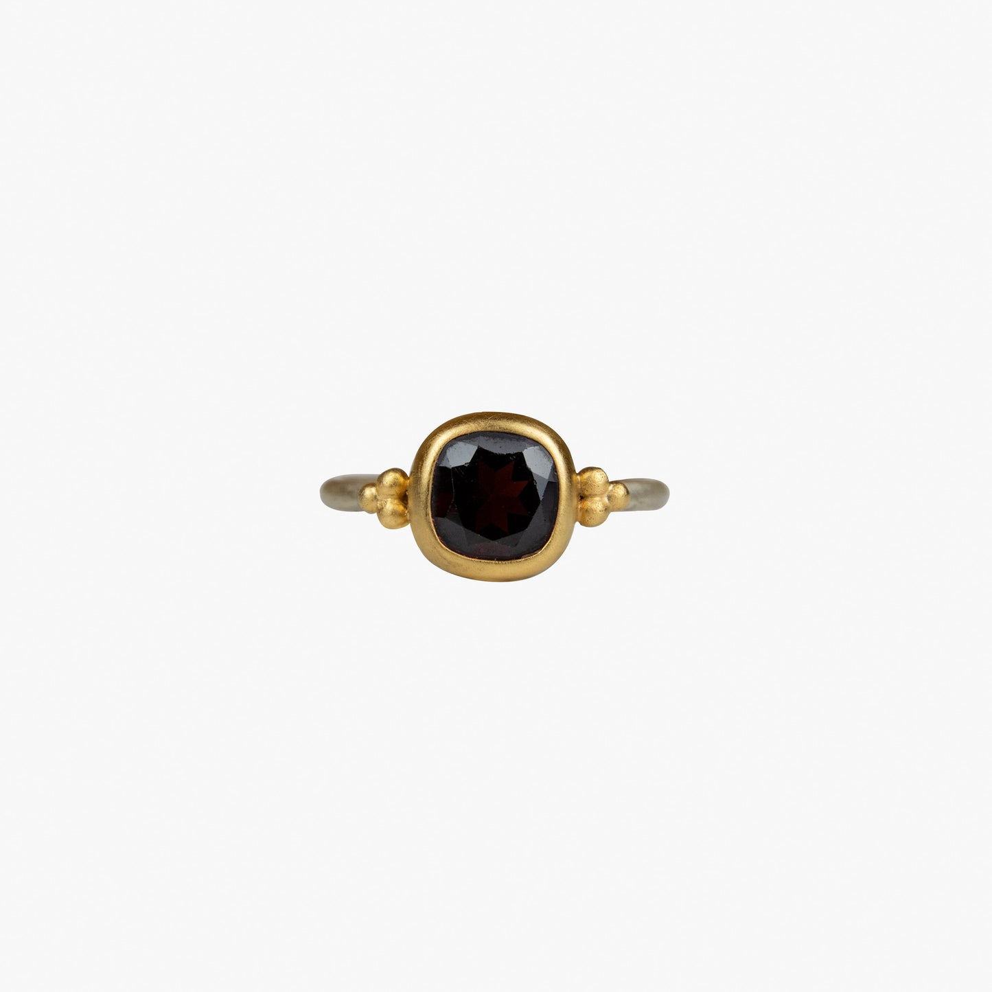 Der Ring KAYA besteht aus Sterlingsilber, einer galvanischen Vergoldung sowie einem Granat-Stein