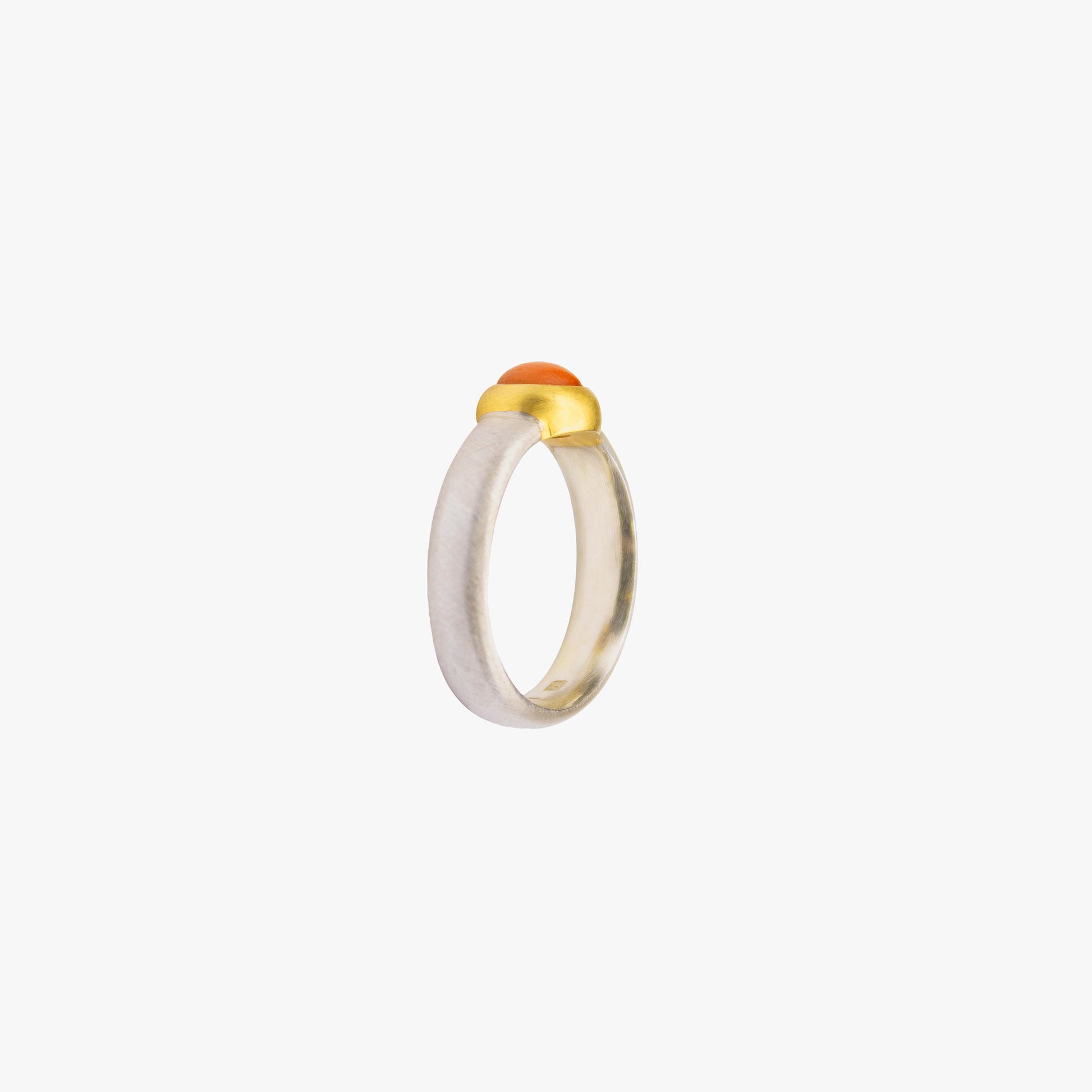 Der Ring ANDI besteht aus Sterlingsilber, einer galvanischen Vergoldung sowie einem Korall-Stein
