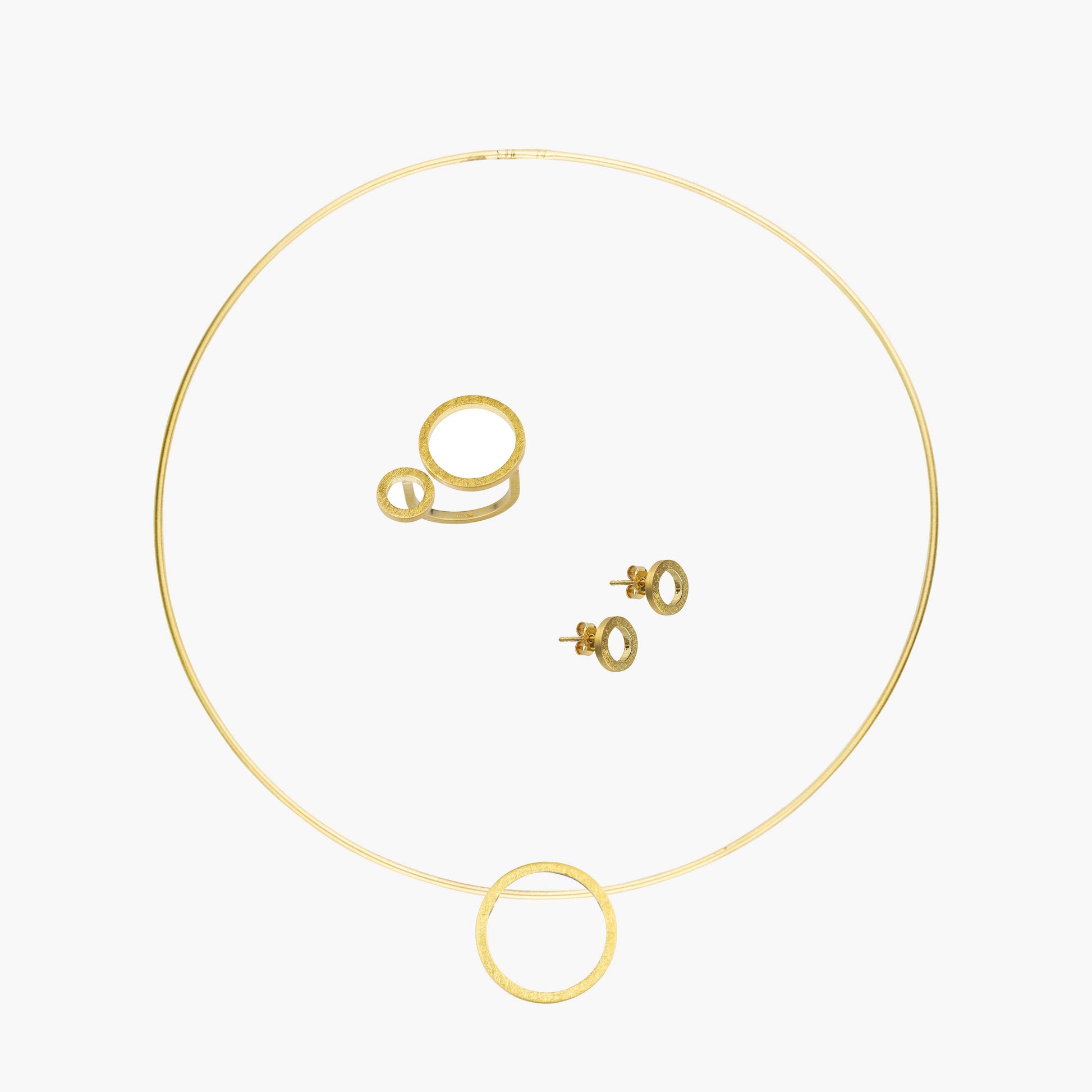 Das MAXI Set CIRCULAR beinhaltet einen Ring, zwei Ohrstecker sowie eine Kette mit Anhänger. Diese bestehen aus 925er Sterlingsilber sowie einer Vergoldung